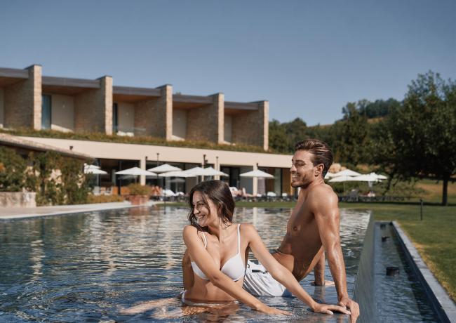 Couple souriant dans la piscine d'un complexe moderne.